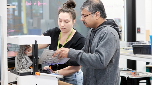 Auaha librarian helping customer make chocolate molds.