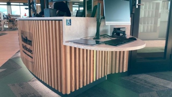 The service desk, which has a lowered ledge at the end with a service computer set up on it.