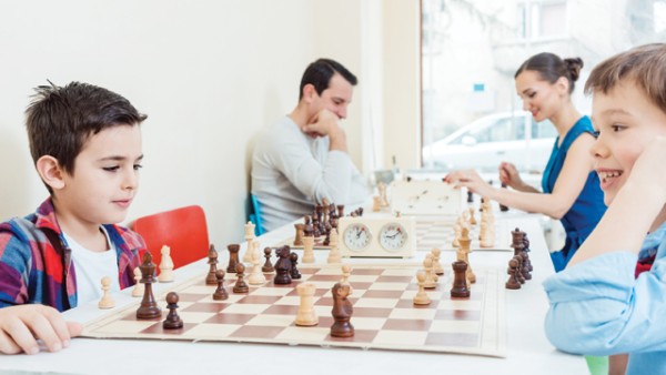 A family of four playing chess.