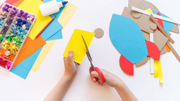 A child using safe-scissors to cut paper. 